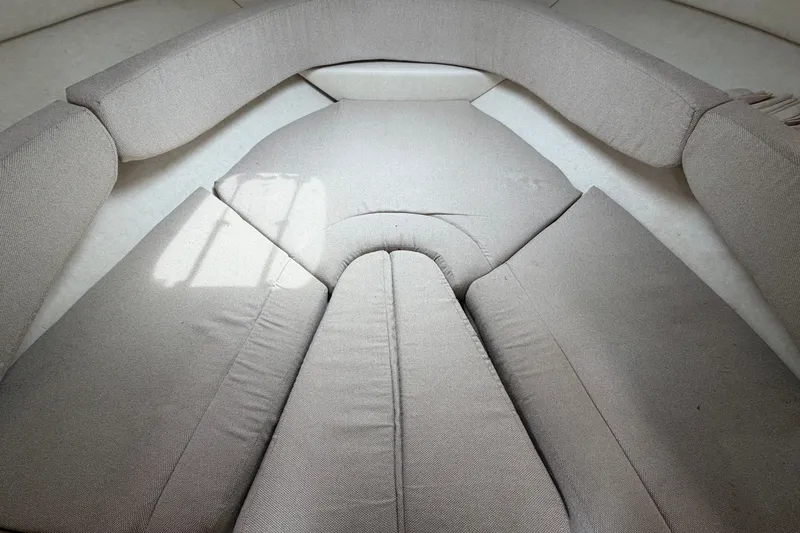 Slide: The Image of Interior seating of 2009 Sea Ray 240 Sundancer boat, featuring beige upholstery. - 70