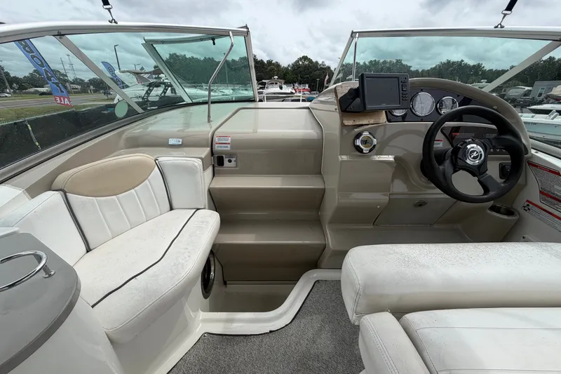 Slide: The Image of 2009 Sea Ray 240 Sundancer boat interior with steering wheel, seating, and dashboard controls. - 29