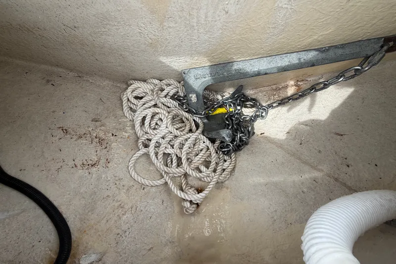 Slide: The Image of An anchor with chain and rope in a boat storage compartment. - 49