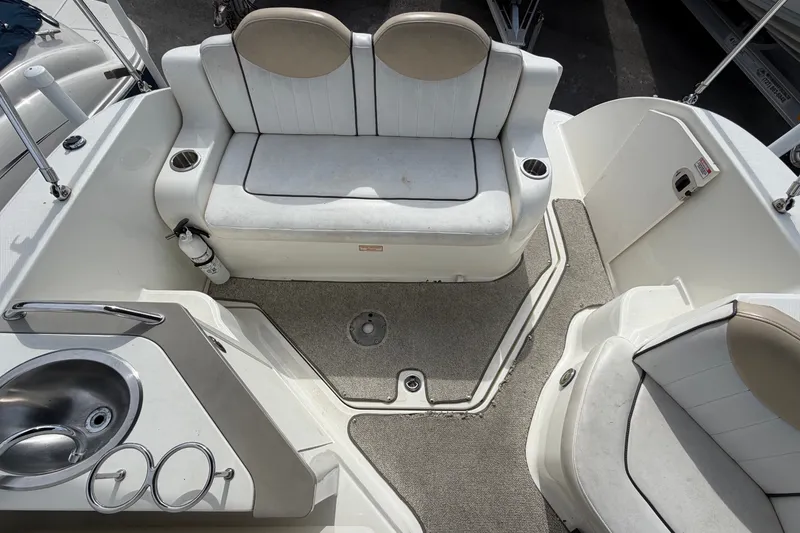 Slide: The Image of The image shows the cockpit of a 2009 Sea Ray 240 Sundancer with seating and a sink. - 27
