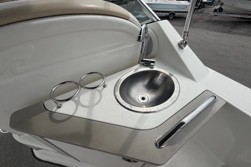 Slide: The Image of 2009 Sea Ray 240 Sundancer boat sink with cup holders and faucet. - 25