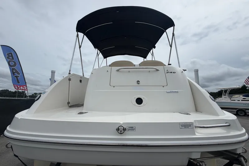Slide: The Image of 2009 Sea Ray 240 Sundancer boat with canopy, displayed for sale outdoors. - 4