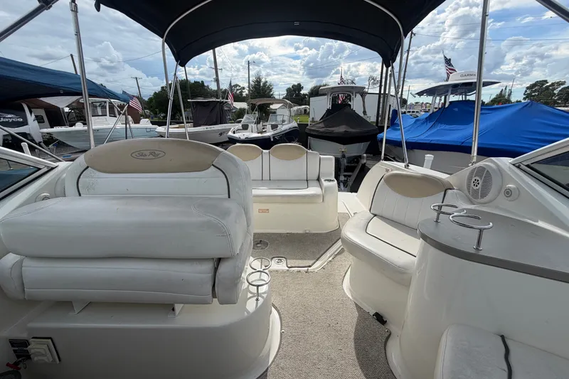 Slide: The Image of 2009 Sea Ray 240 Sundancer boat interior with seating and canopy, docked among other boats. - 26