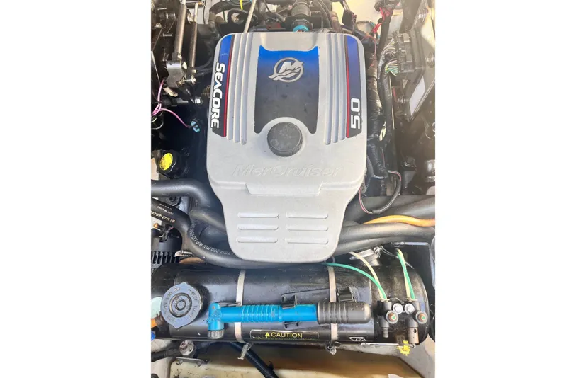 Slide: The Image of The engine compartment of a 2009 Sea Ray 240 Sundancer features a MerCruiser 5.0 engine. - 5