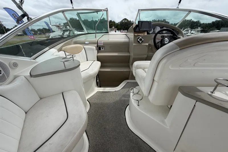 Slide: The Image of 2009 Sea Ray 240 Sundancer boat interior with seating, steering wheel, and cup holders. - 27