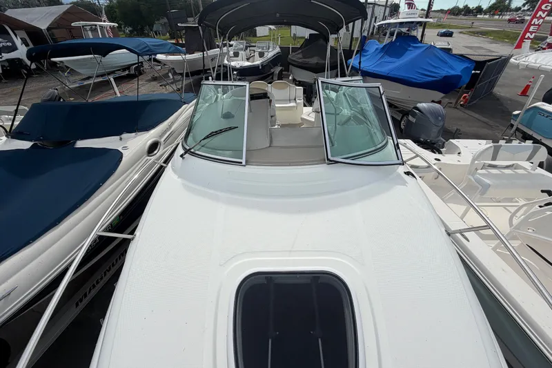 Slide: The Image of 2009 Sea Ray 240 Sundancer boat displayed in a marina with other vessels. - 19