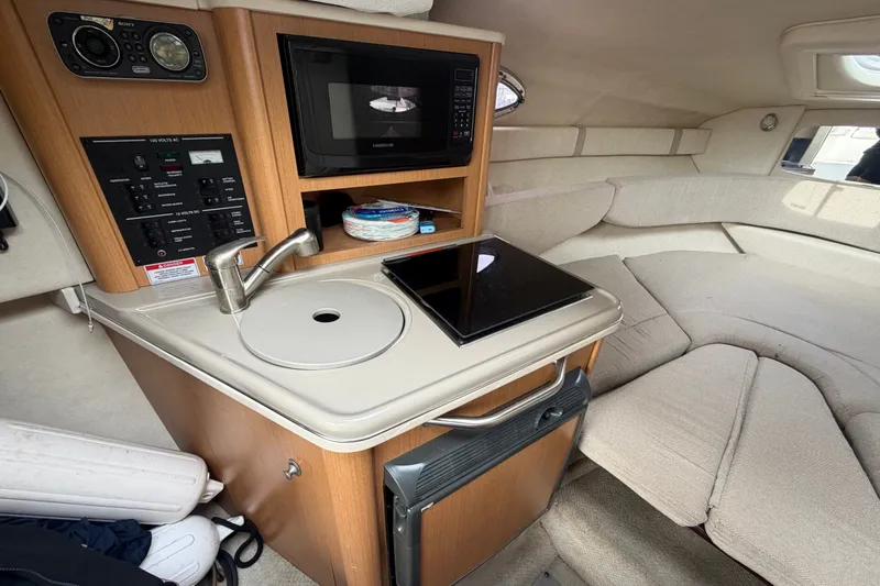 Slide: The Image of Interior of 2009 Sea Ray 240 Sundancer with kitchenette and seating area. - 23