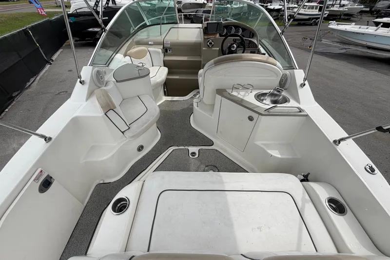 Slide: The Image of 2009 Sea Ray 240 Sundancer boat interior with seating, steering, and sink. - 18