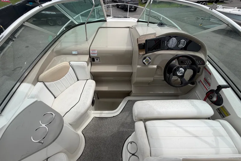 Slide: The Image of 2009 Sea Ray 240 Sundancer boat interior with steering wheel, seating, and dashboard controls. - 28