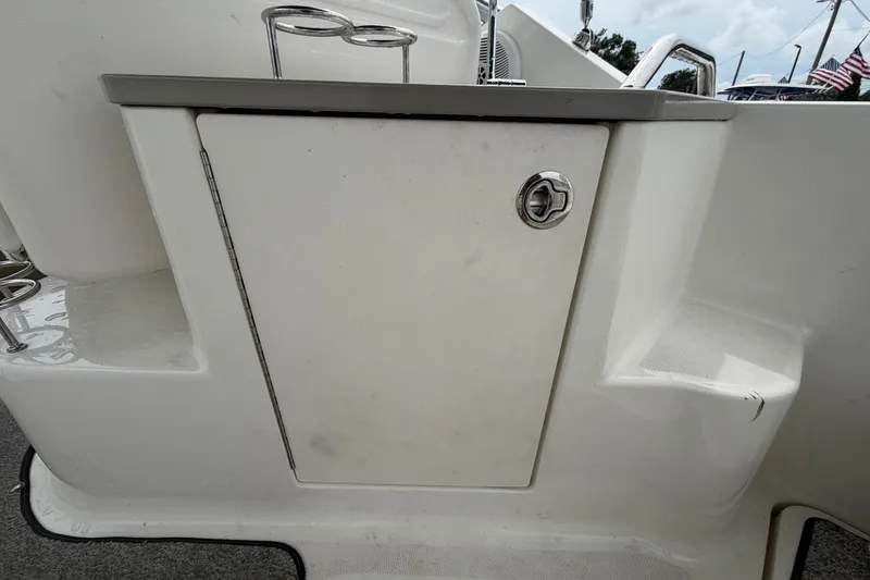Slide: The Image of 2009 Sea Ray 240 Sundancer boat storage compartment with stainless steel cup holders. - 22