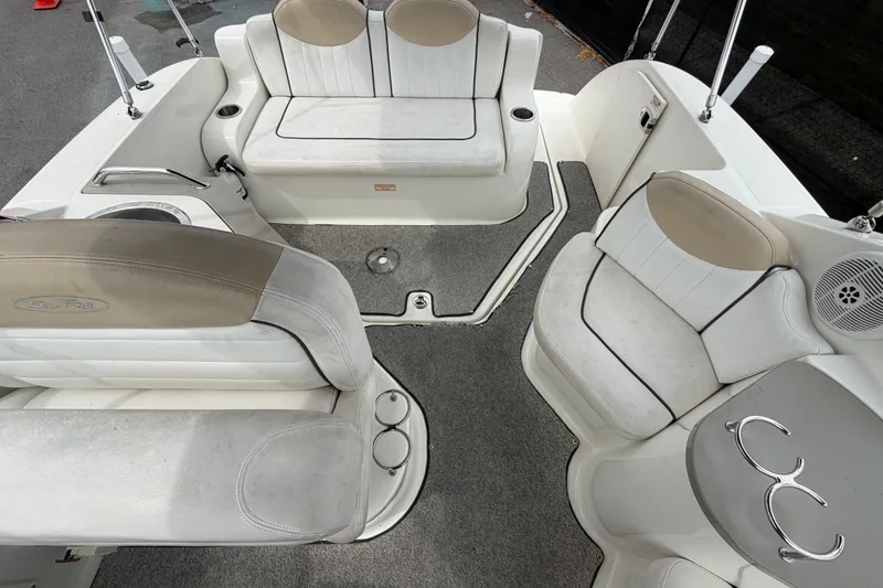 Slide: The Image of 2009 Sea Ray 240 Sundancer boat interior with white seating and cup holders. - 89