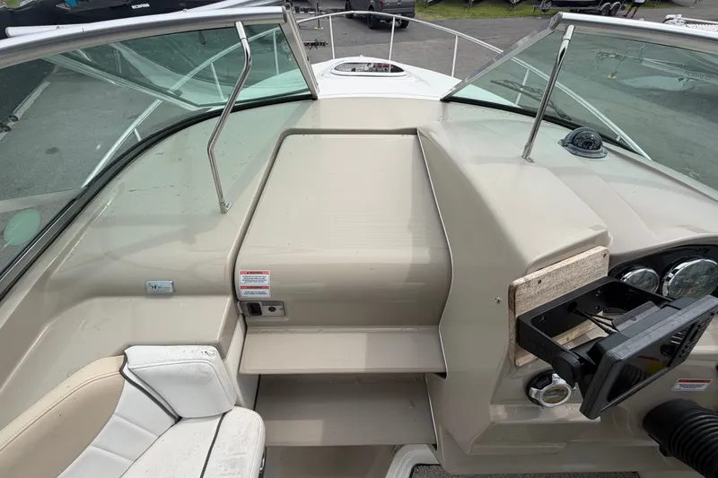 Slide: The Image of 2009 Sea Ray 240 Sundancer boat cockpit with steering wheel and seating area. - 44