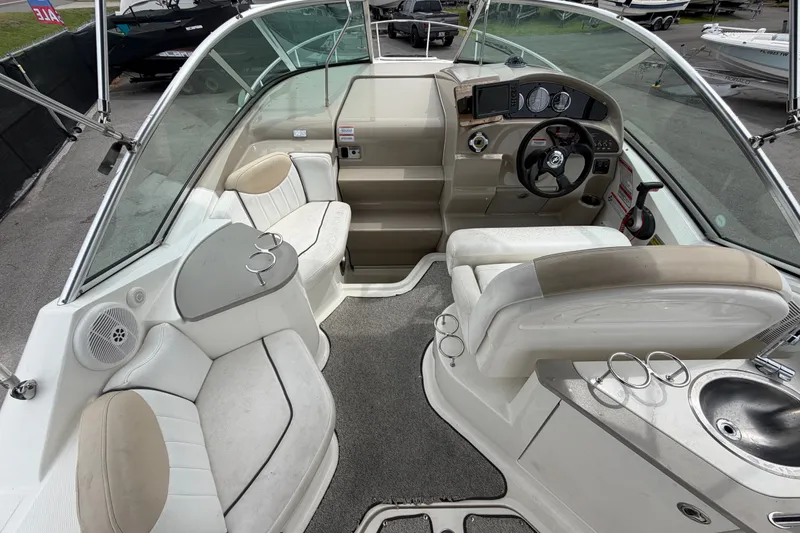 Slide: The Image of 2009 Sea Ray 240 Sundancer boat interior with helm, seating, and sink. - 26