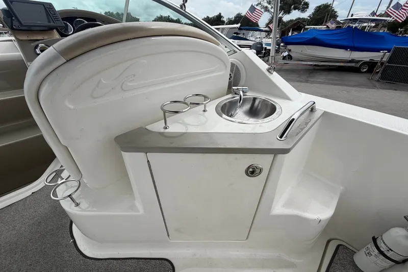 Slide: The Image of 2009 Sea Ray 240 Sundancer boat interior with sink and cup holders. - 21