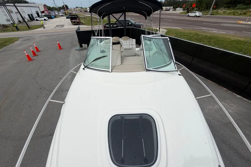 Slide: The Image of 2009 Sea Ray 240 Sundancer boat on trailer, parked near road with traffic cones. - 50