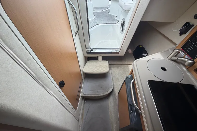 Slide: The Image of Interior view of 2009 Sea Ray 240 Sundancer cabin with kitchenette and steps. - 77