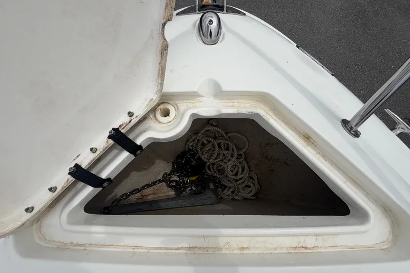 Slide: The Image of An open anchor compartment with ropes and a chain on a Sea Ray 240 Sundancer boat. - 48
