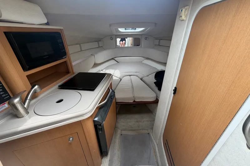 Slide: The Image of Interior of 2009 Sea Ray 240 Sundancer boat with kitchenette and cozy seating area. - 56