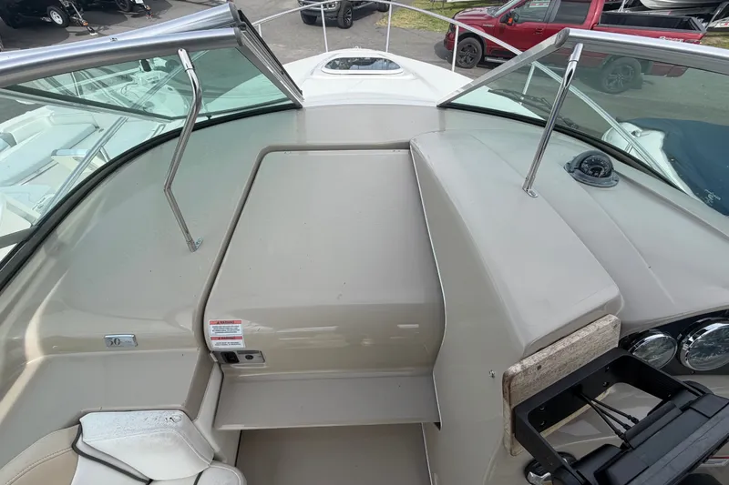 Slide: The Image of 2009 Sea Ray 240 Sundancer boat cockpit with windshield and seating area. - 16