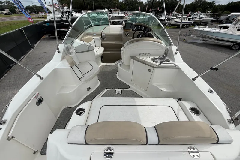 Slide: The Image of 2009 Sea Ray 240 Sundancer boat interior with seating and helm, docked at marina. - 14