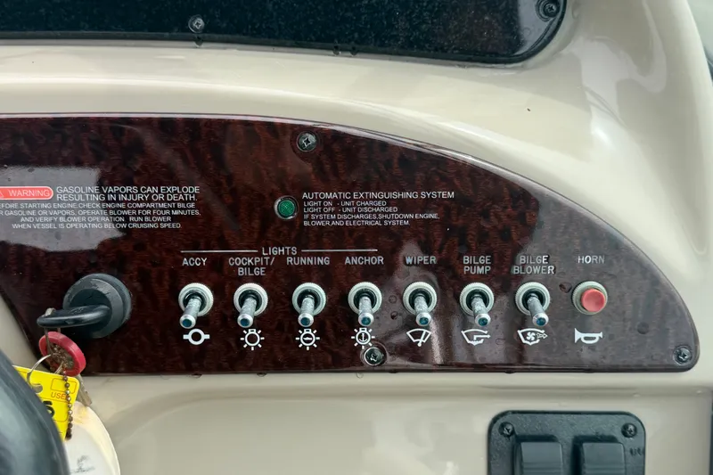 Slide: The Image of Control panel of a 2009 Sea Ray 240 Sundancer boat with various switches and warnings. - 42