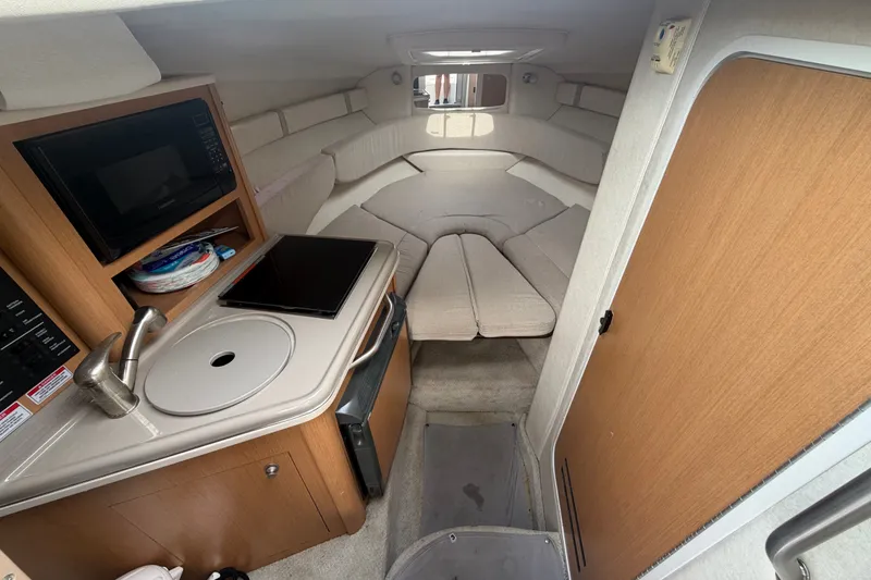 Slide: The Image of 2009 Sea Ray 240 Sundancer cabin interior with kitchenette and cozy seating area. - 21