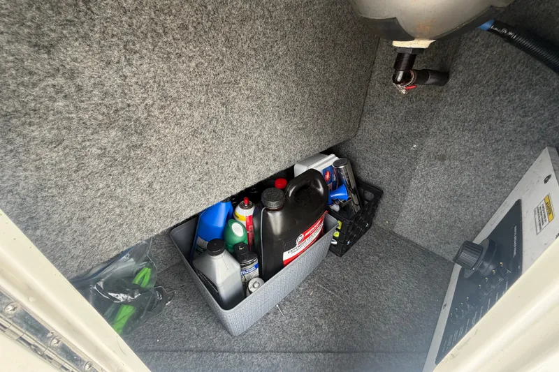Slide: The Image of Storage compartment of a 2009 Sea Ray 240 Sundancer with maintenance supplies. - 23