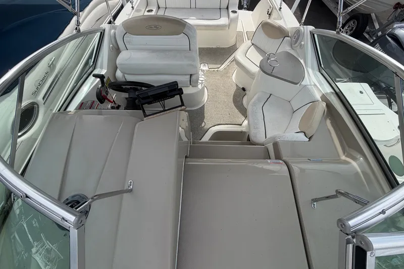 Slide: The Image of Interior of a 2009 Sea Ray 240 Sundancer with white seating and helm console. - 25