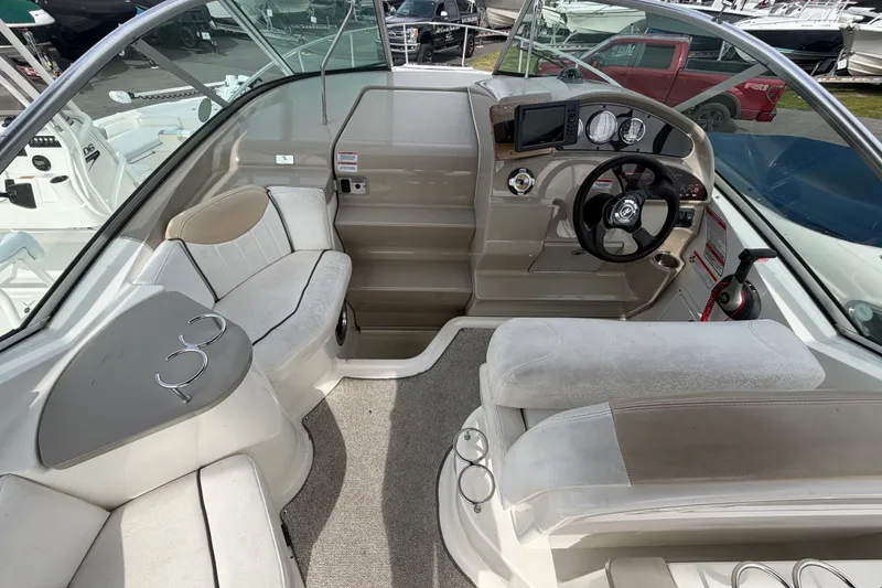 Slide: The Image of 2009 Sea Ray 240 Sundancer boat interior with steering wheel and seating area. - 12