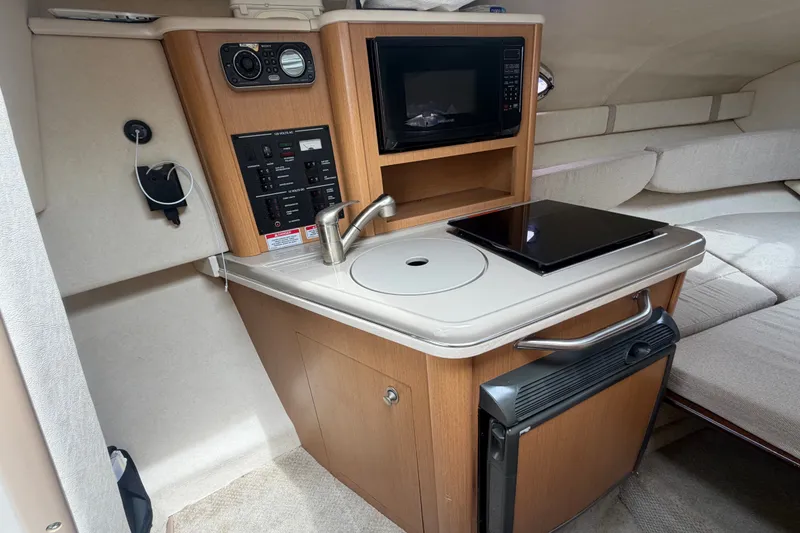 Slide: The Image of Compact kitchen area in 2009 Sea Ray 240 Sundancer boat with microwave and sink. - 58
