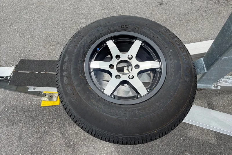 Slide: The Image of Boat trailer tire on a Sea Ray 240 Sundancer, 2009 model, parked on asphalt. - 103