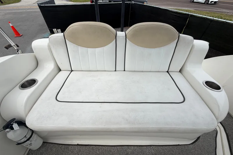 Slide: The Image of 2009 Sea Ray 240 Sundancer boat seating area with cup holders and fire extinguisher. - 92