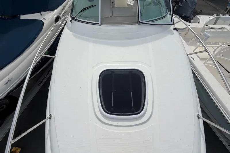 Slide: The Image of The image shows the foredeck of a 2009 Sea Ray 240 Sundancer with a hatch. - 18