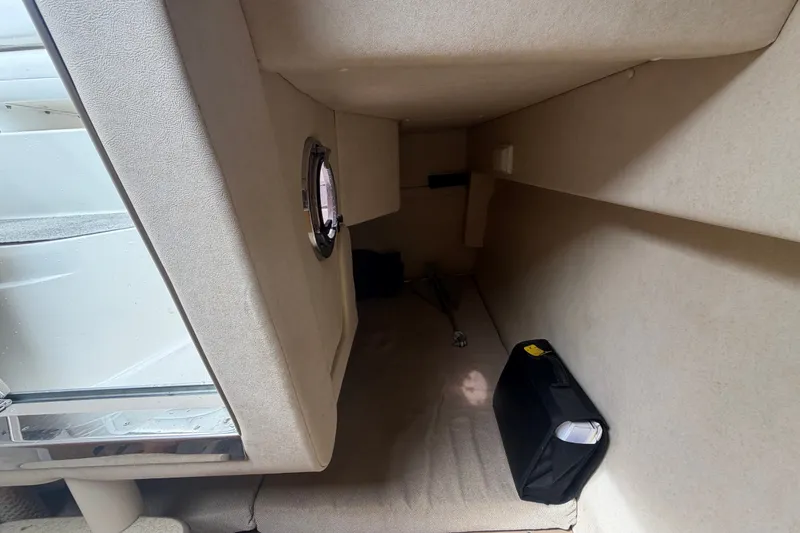 Slide: The Image of Interior cabin of 2009 Sea Ray 240 Sundancer boat, featuring compact storage space. - 84