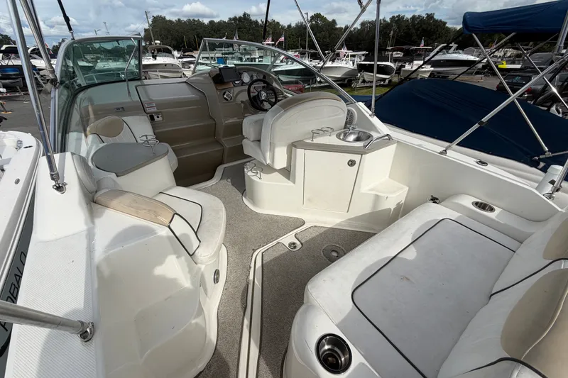 Slide: The Image of 2009 Sea Ray 240 Sundancer boat interior with seating and helm, docked at marina. - 10