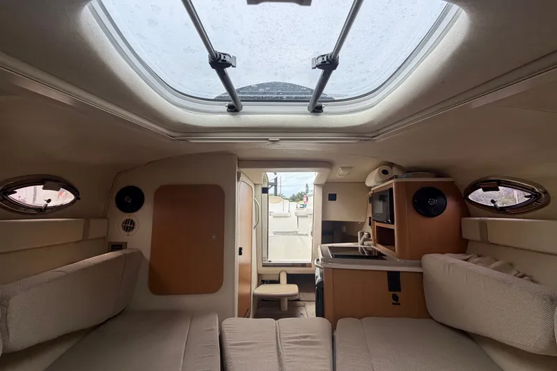 Slide: The Image of Interior of 2009 Sea Ray 240 Sundancer boat with skylight and cozy seating area. - 73