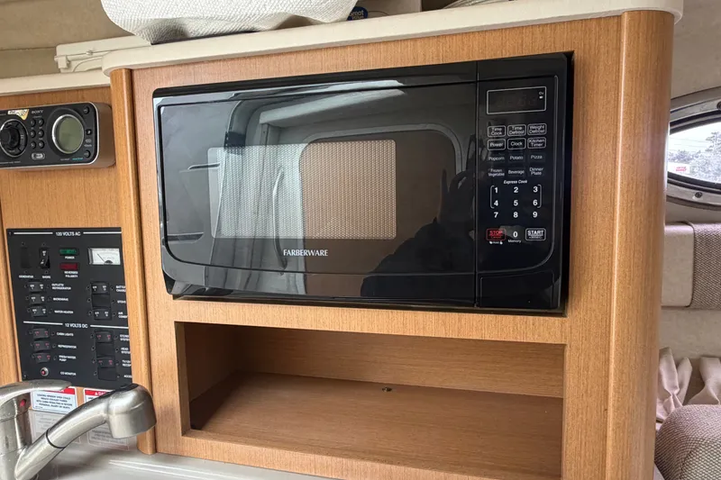 Slide: The Image of Microwave and control panel inside 2009 Sea Ray 240 Sundancer boat cabin. - 63