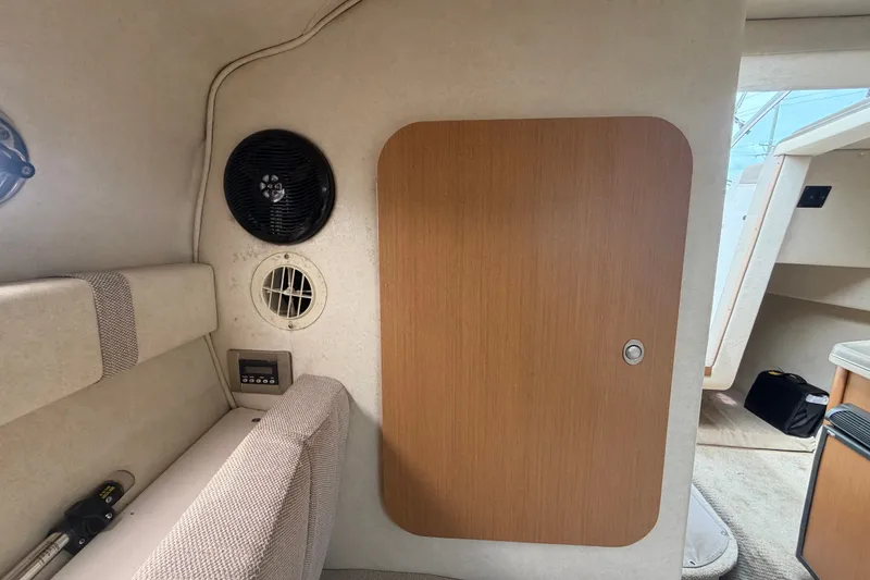 Slide: The Image of Interior of 2009 Sea Ray 240 Sundancer boat with seating and wooden door. - 74