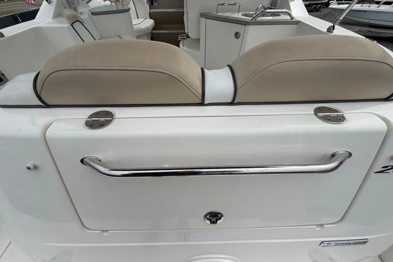 Slide: The Image of 2009 Sea Ray 240 Sundancer boat interior with beige seating and stainless steel handle. - 16
