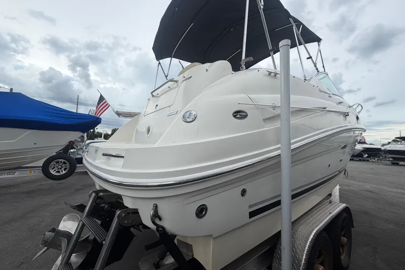 Slide: The Image of 2009 Sea Ray 240 Sundancer boat on trailer, with American flag in background. - 1