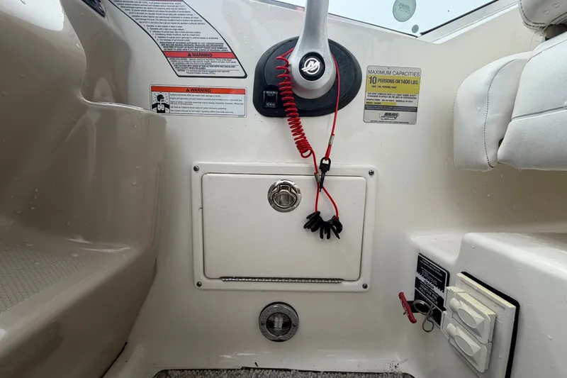 Slide: The Image of 2009 Sea Ray 240 Sundancer cockpit controls with safety warnings and capacity details. - 36