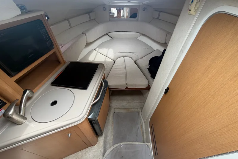 Slide: The Image of Interior of 2009 Sea Ray 240 Sundancer boat with kitchenette and seating area. - 57