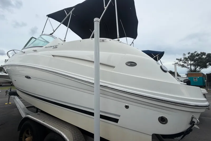 Slide: The Image of 2009 Sea Ray 240 Sundancer boat on trailer with canopy, overcast sky background. - 5