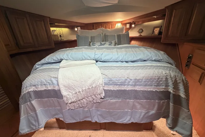 Slide: The Image of Cozy bedroom interior of 1986 Viking 48 Motor Yacht with elegant bedding and wooden cabinetry. - 36