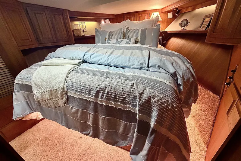 Slide: The Image of Cozy bedroom interior of 1986 Viking 48 Motor Yacht with plush bedding and warm lighting. - 42