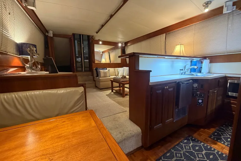 Slide: The Image of Interior of 1986 Viking 48 Motor Yacht with cozy seating and wooden cabinetry. - 18