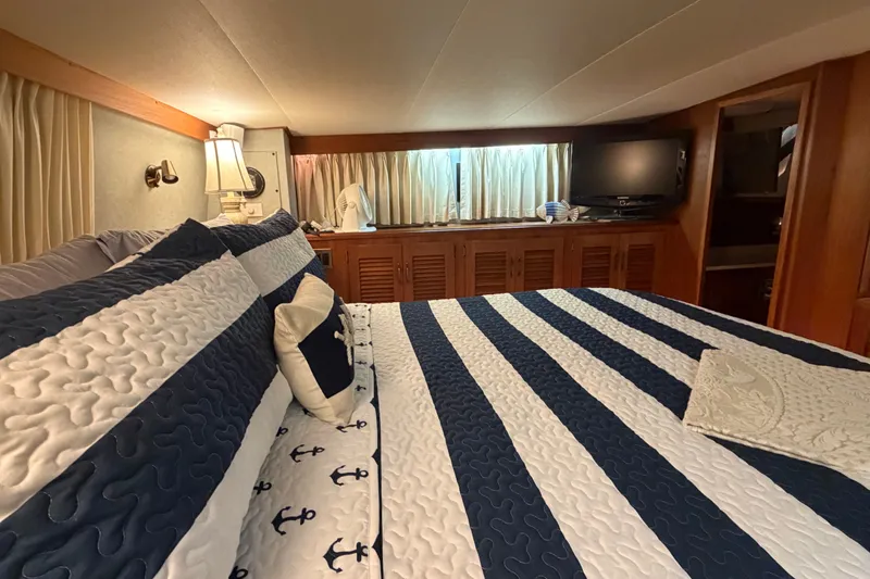 Slide: The Image of Luxurious bedroom interior of 1986 Viking 48 Motor Yacht with nautical-themed bedding. - 25