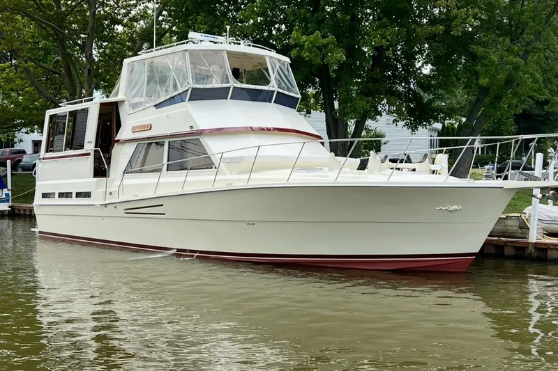 Slide: The Image of 1986 Viking 48 Motor Yacht docked on calm water, surrounded by lush greenery. - 1