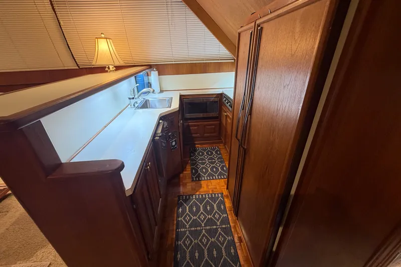 Slide: The Image of 1986 Viking 48 Motor Yacht kitchen with wood cabinetry, sink, and appliances. - 15