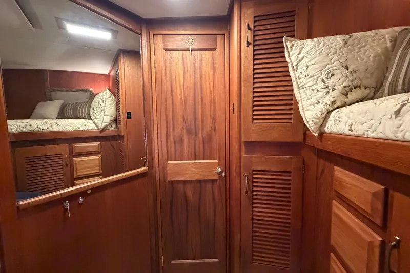 Slide: The Image of Interior of 1986 Viking 48 Motor Yacht with wooden cabinetry and cozy bedding. - 32